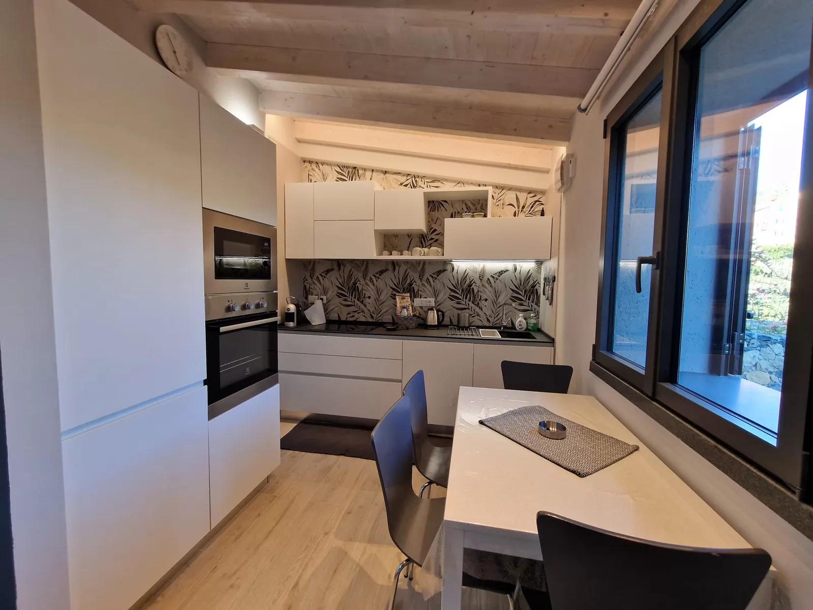 La cucina de I Particolari con la grande vetrata che si apre sul giardino