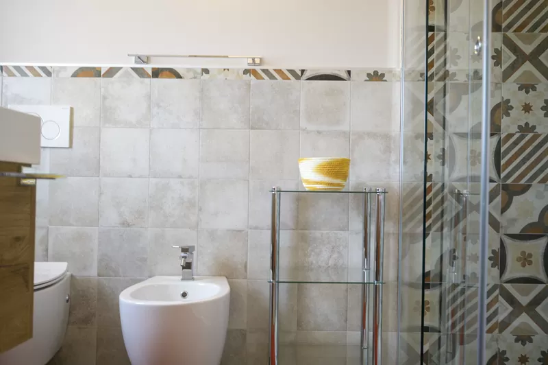 Il bagno con la doccia e le piastrelle decorate