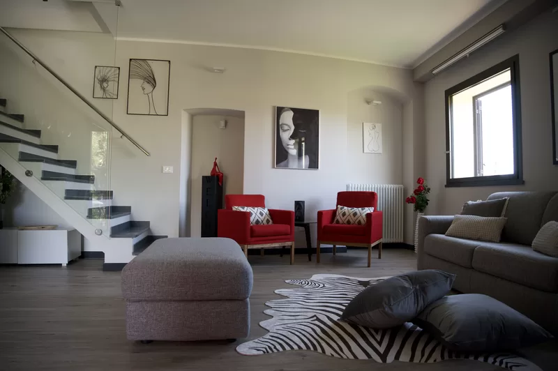 Il soggiorno di Ritratto di Donna con le poltrone rosse e i ritratti alle pareti